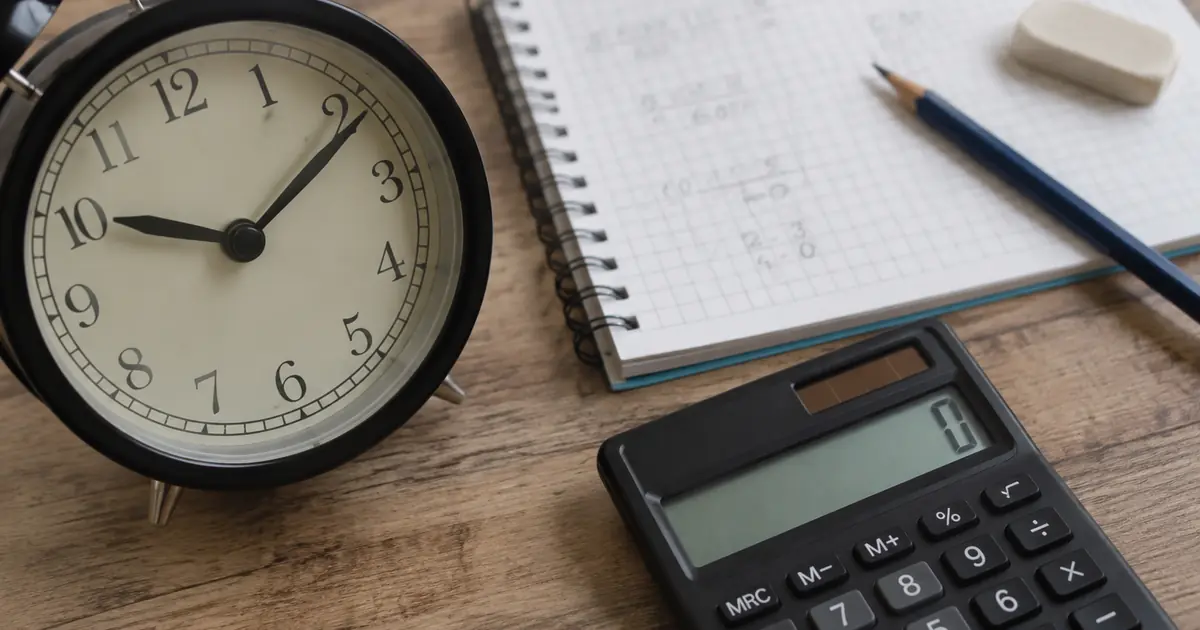 Relógio, calculadora e caderno usados na conversão de horas decimais
